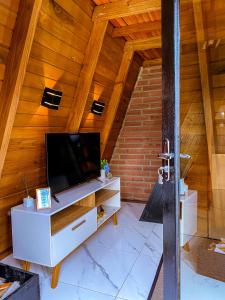 a living room with a tv in a wooden ceiling at Morada do Corujão - Aconchego in Praia Grande
