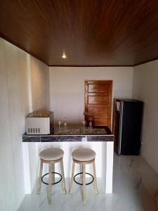 a kitchen with two bar stools and a counter with a sink at Cabanas Zamoray 