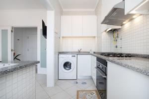 een witte keuken met een wasmachine bij One of the Best Views Costa Nova II in Gafanha da Encarnação