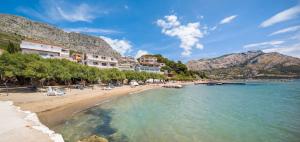 une plage avec un tas de bâtiments et l'eau dans l'établissement Apartments Antonio, à Duće