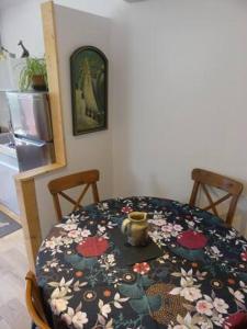 a dining room table with a flower patterned table cloth at Maison de village au calme axe Annecy - Genève in Villy-le-Pelloux