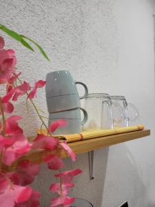 a shelf with two mugs and a tea pot and flowers at Lovely Oasis in Schmelz