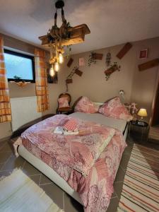 a bedroom with a bed with a pink comforter at Lovely Oasis in Schmelz