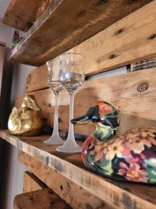 półka z dwoma kieliszkami wina i ptakiem na niej w obiekcie Lovely Oasis w mieście Schmelz