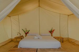 ein Schlafzimmer mit einem Bett in einem Zelt in der Unterkunft Manoush Beach in Buritaca