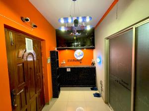 a bathroom with orange walls and a tv in a room at zooFamily in Dhaka
