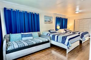 twee bedden in een kamer met blauwe gordijnen bij Casa Wynwood Miami in Miami