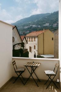 d'un balcon avec deux chaises et une table. dans l'établissement Na Stanza in centro, à Ravello