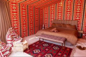 1 dormitorio con cama y alfombra en desert splendor camp & jeep tours, en Wadi Rum