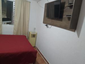 um quarto com uma cama e uma televisão na parede em Casa com ar condicionado perto da Expo SP e Jd Zoologico em São Paulo
