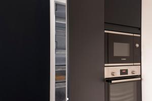 a kitchen with a refrigerator and a microwave at Luxurious London Studios in Harrow