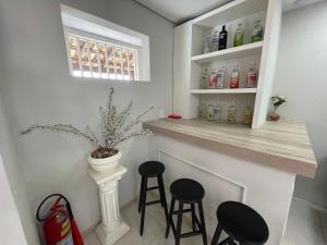 - un bar dans une cuisine avec deux tabourets dans l'établissement The Férias | Suites Luxo, à Cabo Frio
