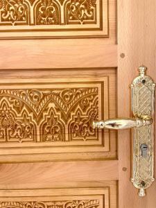 une poignée de porte en or sur une porte en bois dans l'établissement Luxurious Riad Center Rabat Dar Al Jeld, à Rabat