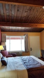 Un dormitorio con una cama grande y una ventana en Forks Motel en Forks