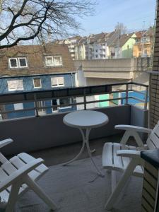 Un balcón con una mesa y sillas en un tejado. en Studio Flat Medien Hafen 30minToFair, en Düsseldorf 5 fotos más