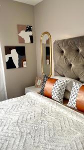 a bedroom with a bed and a mirror at Saffron Place @ 2bed Apt Midrand in Midrand