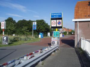 un letrero de calle al lado de una carretera al lado de un edificio en B&B Fam. Tavenier en Vrouwenpolder