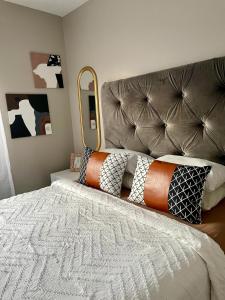 um quarto com uma cama grande e uma grande cabeceira. em Saffron Place @ 2bed Apt Midrand em Midrand