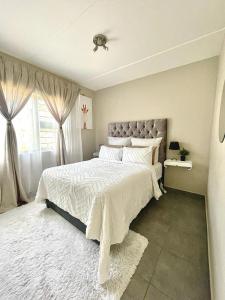 Un dormitorio con una cama grande y una ventana en Saffron Place @ 2bed Apt Midrand, en Midrand