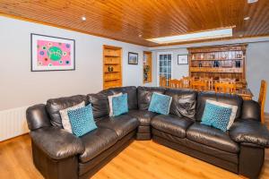 a brown leather couch in a living room at Mullally House Liscannor (Wild Atlantic Way) in Liscannor