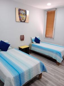 a room with two beds and a portrait of a woman at hostal mancora in Santiago