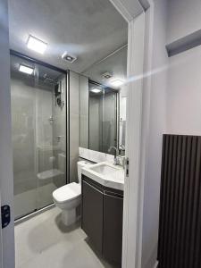 Un baño con inodoro, lavabo y ducha. en Studio 905, en Marília