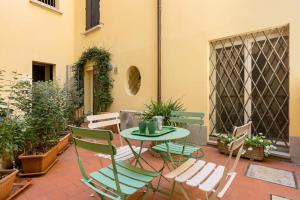 a patio with a table and chairs and plants at Casa De' Castagnoli, AC/Wifi in Bologna