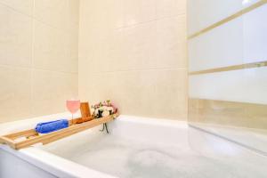 a bathroom with a tub and a glass of wine at Le Majestic Blue - Métro 8/Hôpital Henri Mondor in Créteil +15 photos