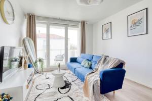 a living room with a blue couch and a tv at Le Majestic Blue - Métro 8/Hôpital Henri Mondor in Créteil