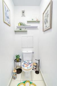 a white bathroom with a toilet and two shelves at Le Majestic Blue - Métro 8/Hôpital Henri Mondor in Créteil