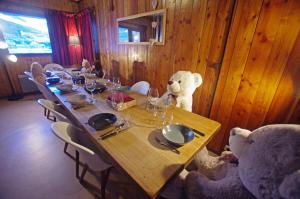 a large wooden table with two teddy bears sitting around it at Chalet Pre Saint-jacques - Chalets pour 15 Personnes 601 in Tignes