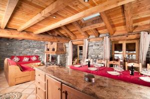 a kitchen with a table and chairs in a cabin at Chalet Les Champs Du Pont - Chalets pour 15 Personnes 611 in Tignes
