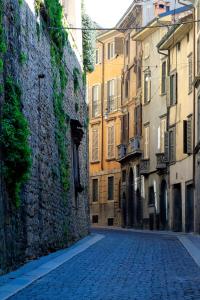 a cobblestone street in an alley between buildings at Livinn Bergamo THE WALL in Bergamo