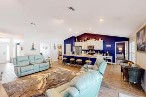 sala de estar con muebles azules y cocina en Blissful Retreat, en North Port