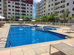 a large swimming pool with chairs and buildings at Recanto Junto a Praia in Aracaju