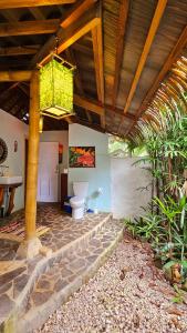 a bathroom with a toilet under a wooden ceiling at Rameen- Private Garden House near Cocles Beach in Puerto Viejo +5 photos