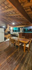 uma grande cozinha com uma mesa de madeira e cadeiras em Cobertura Duplex Premium em Ubatuba