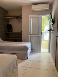 um quarto com 2 camas e uma porta de vidro deslizante em Cobertura Duplex Premium em Ubatuba