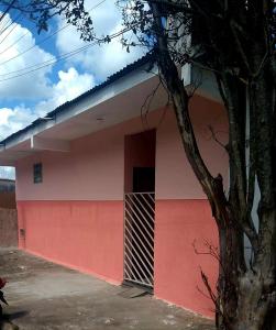 un edificio rojo y blanco con una puerta en Kit net amplo, en São Lourenço