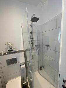 La salle de bains est pourvue d'une douche en verre et de toilettes. dans l'établissement Leipzig City Apartment - Südperle - direkt im Geschehen, à Leipzig