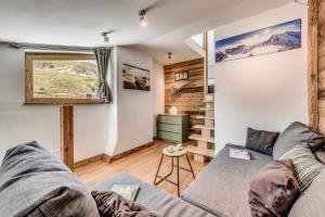 ein Wohnzimmer mit einem Sofa und einem Fenster in der Unterkunft Résidence Hameaux De Toviere - 3 Pièces pour 6 Personnes 711 in Tignes