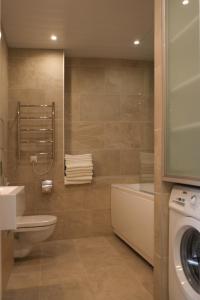 een badkamer met een wastafel en een wasmachine bij MyApartments in Tallinn