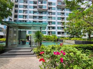 un gran edificio de apartamentos con piscina y flores en 中央公寓 1bedroom Centrio Condominium, en Ban Rangeng