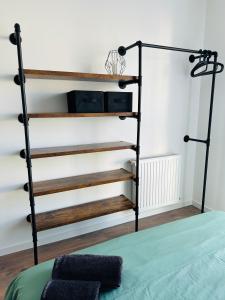 Un dormitorio con una cama con una estantería de metal y madera en Chambre privative et confortable, en Angers