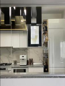 a kitchen with white cabinets and a microwave at Penthouse Împăratul Traian in Craiova