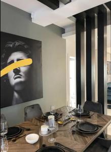 a dining room table with a picture of a man on the wall at Penthouse Împăratul Traian in Craiova