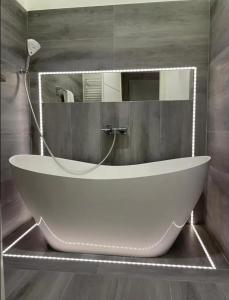 Penthouse Împăratul Traian في كرايوفا: حوض أبيض في الحمام مع مرآة