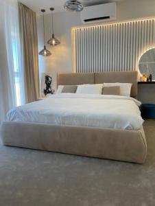 1 dormitorio con 1 cama grande con sábanas blancas en Penthouse Împăratul Traian, en Craiova