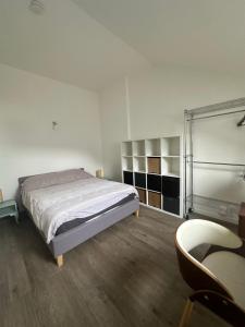 ein Schlafzimmer mit Bett, Stuhl und Schreibtisch in der Unterkunft 2 pièces duplex Issy Les Moulineaux Ascenseur internet in Issy-les-Moulineaux