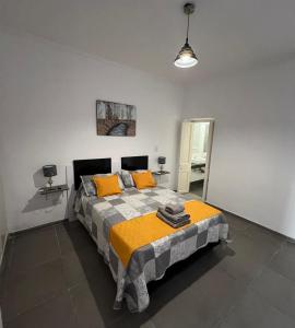 a bedroom with a large bed with orange pillows at Departamento Mis Nonos 3 in Mendoza